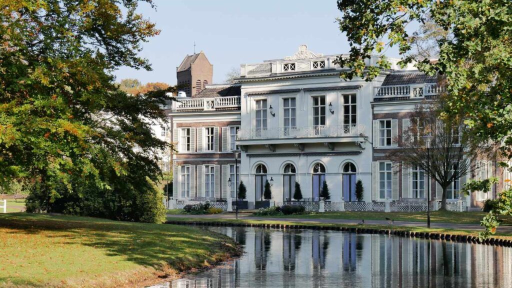 Herrschaftliche historische Villa an einem Park mit Teich.